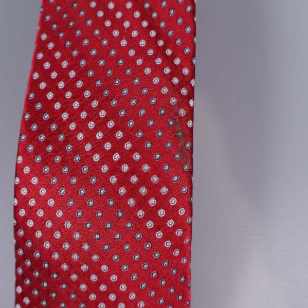 Närbild på den röda slipsspetsen med små vita prickar