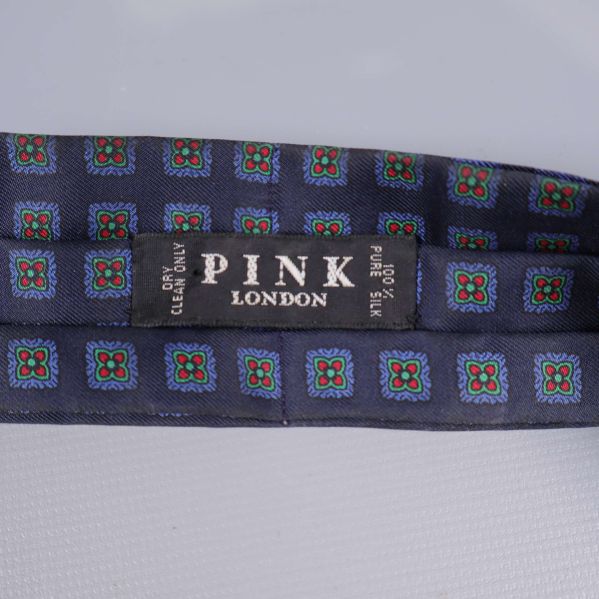 Etikett på scarf visar PINK London och 100% silk