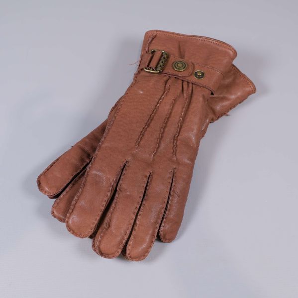 En brun handske visas med spänne och sömmar