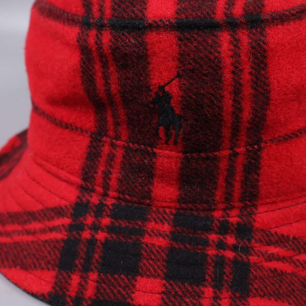 Närbild på broderad logotyp på rutig bucket hat