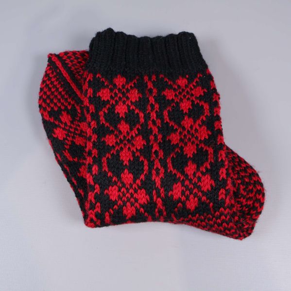 Hopvikta röd- och svartmönstrade stickade strumpor med ribbad mudd