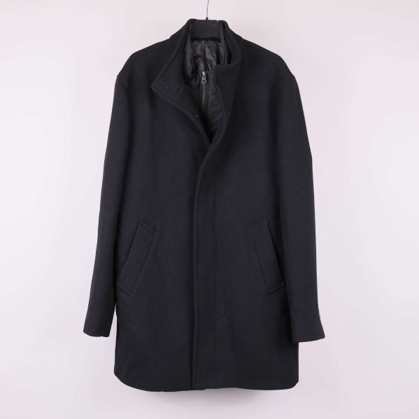 Svart kappa med rak passform upphängd på galge