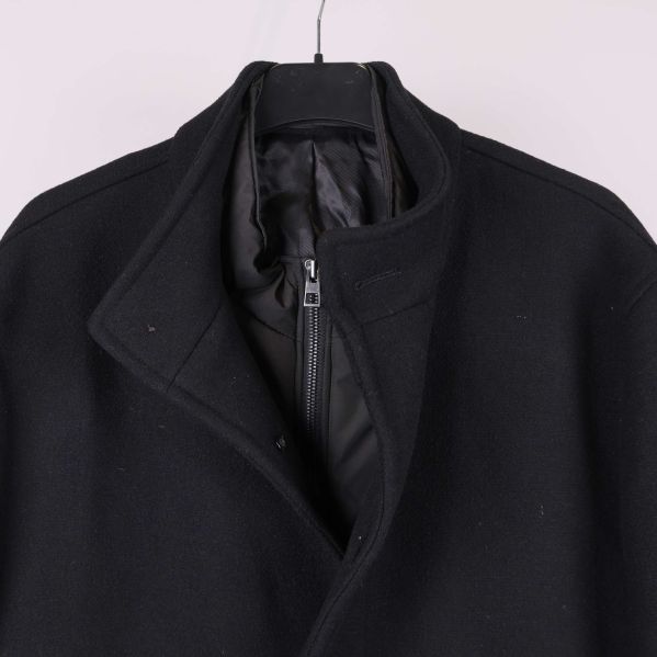 Närbild på ståkrage och dold dragkedja på kappa