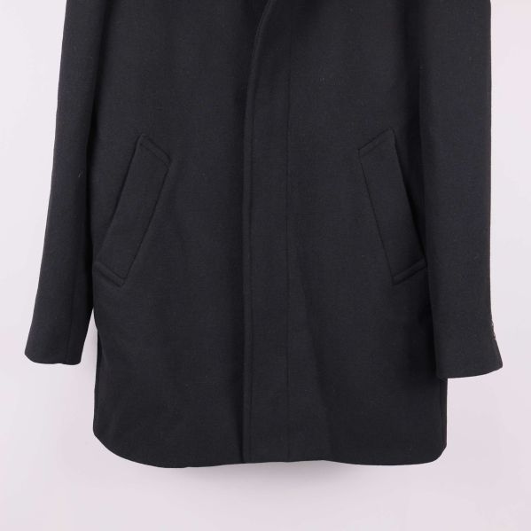 Nedre delen av svart kappa med två snedställda fickor