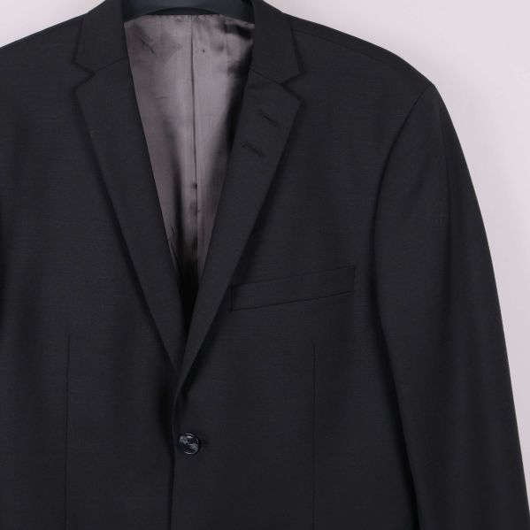 Närbild av överdelen på svart kavaj och slag