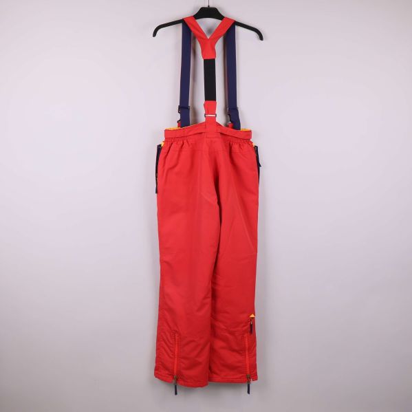 Baksidan av röda skidbyxor med blå och röda hängslen