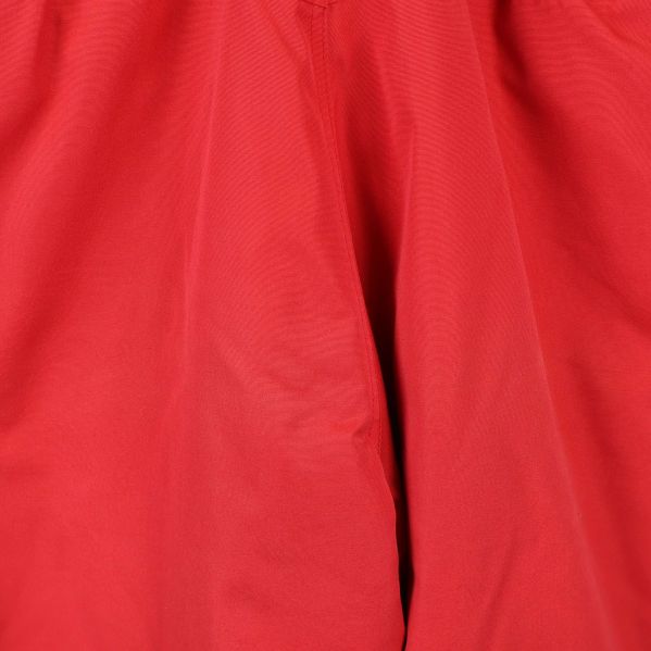 Materialdetalj på röda skidbyxor i närbild