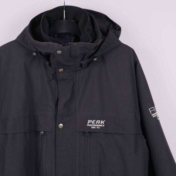 Närbild på logga och detaljer vid bröstet på svart jacka