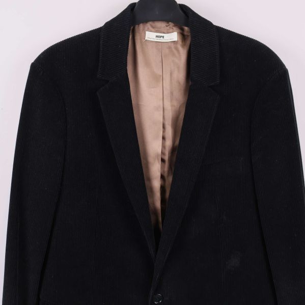 Närbild på kavajens överdel med krage och knapp framtill