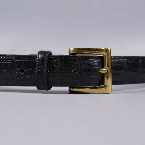 Närbild på bältets krokopräglade läder och spännet