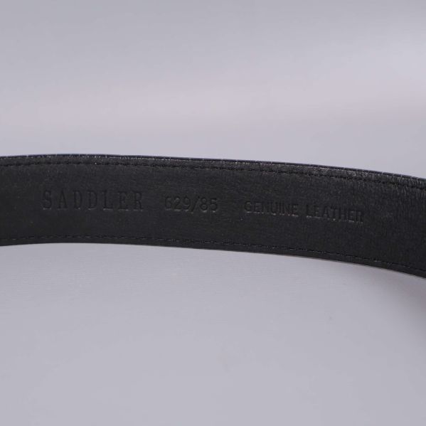 Stansad text med Saddler och genuine leather på insidan