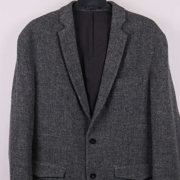 Närbild på kavajen med två knappar och fickor fram