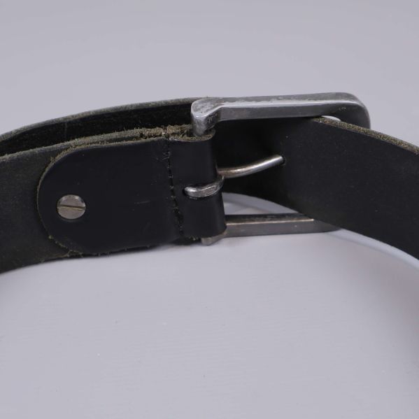 Baksidan av svart bälte med synlig skruv