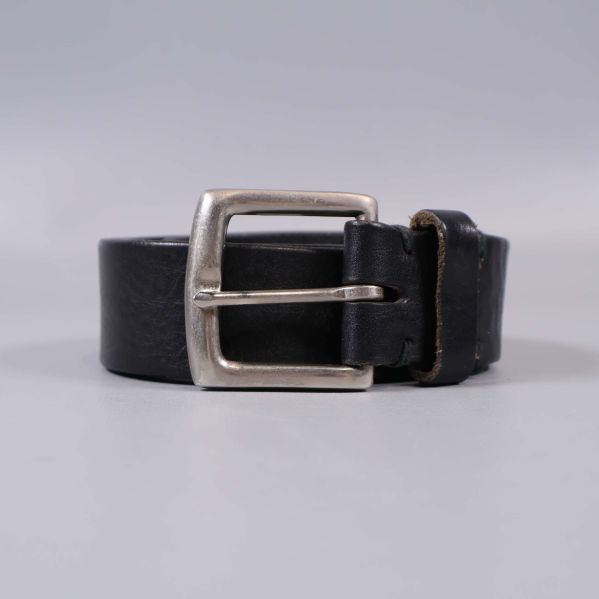 Framifrån vy av svart bälte rullat med spännet i fokus