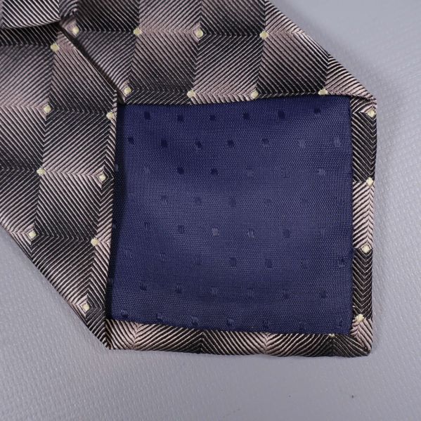 Närbild på mörkblå vadderad spets på slipsen