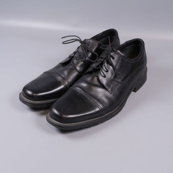 Klassiska svarta finskor i sned vinkel på grå bakgrund