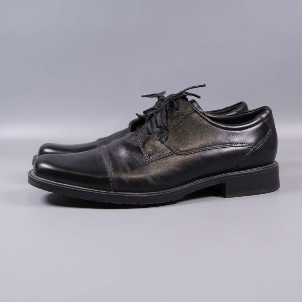 Svarta snörskor från andra sidan på grå bakgrund