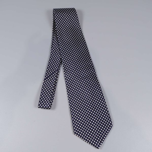 Helbild av mörkblå slips med rutmönster i vitt