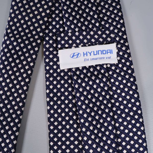 Närbild på Hyundai-etikett på rutmönstrad slips