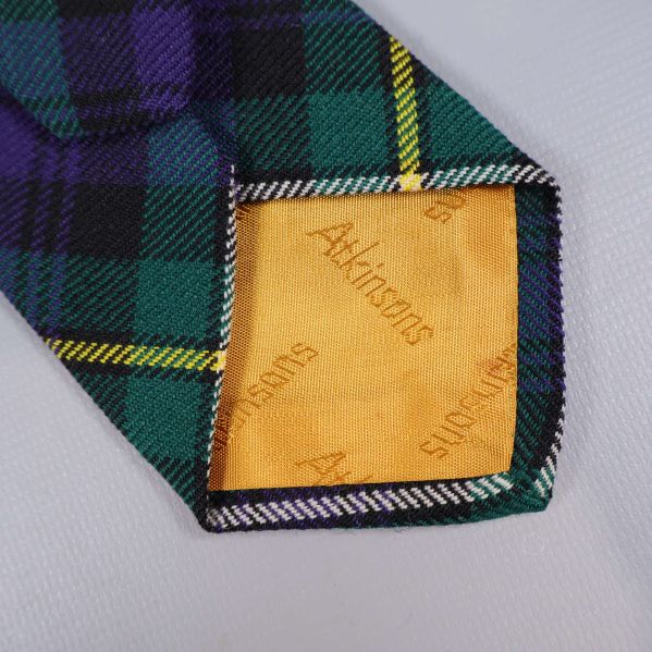 Närbild insida på slipsen med gult foder och Atkinsons-logga