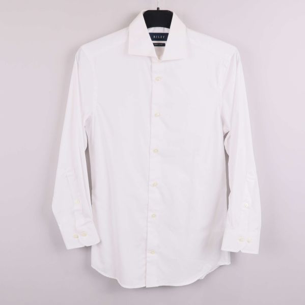 Vit skjorta med långa ärmar hängandes på galge