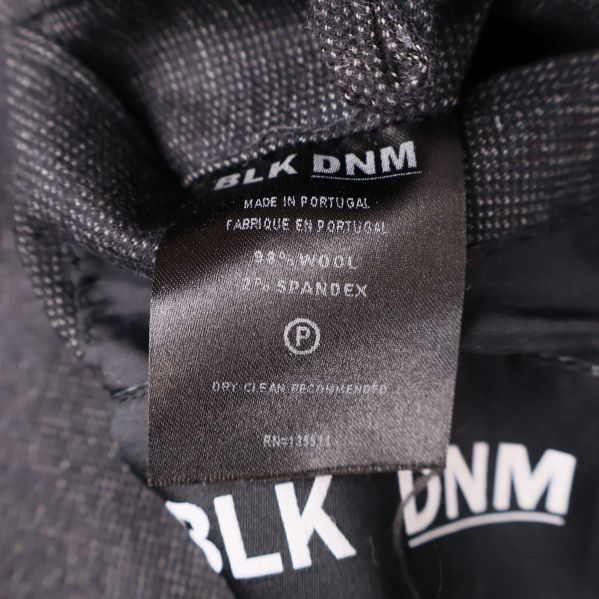 Tvättrådslapp med materialinformation i kavajen