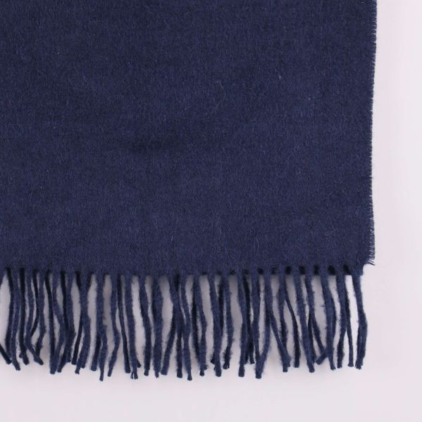 Närbild på halsdukens fransar och tygstruktur