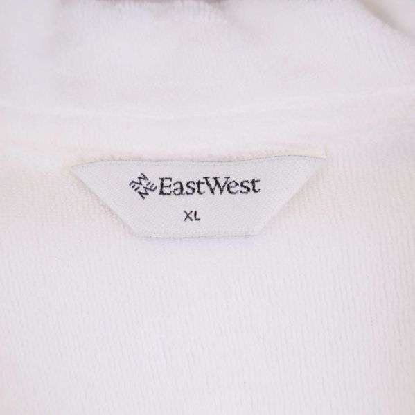 Närbild etikett East West och storlek XL