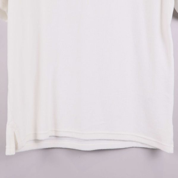 Närbild på vit pikétröjas nederkant