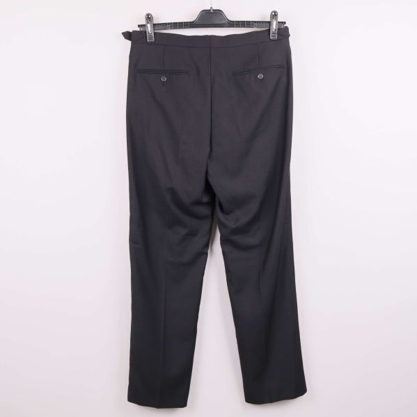 Svarta kostymbyxor hängande på galge, bakifrån