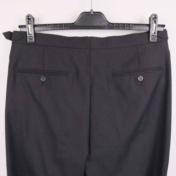 Närbild på bakfickor med knappar på byxa