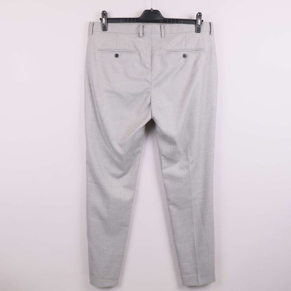 Baksidan av ljusgrå kostymbyxa med knäppning på bakfickor