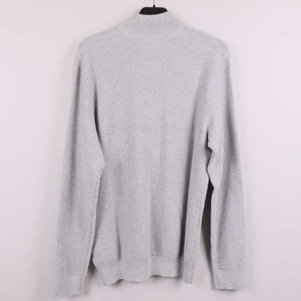 Grå stickad tröja visad bakifrån på galge