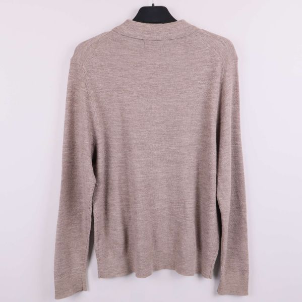 Baksida av beige långärmad stickad tröja på galge