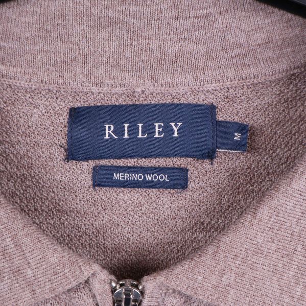 Närbild på RILEY-märke och merinoull-etikett i nacken