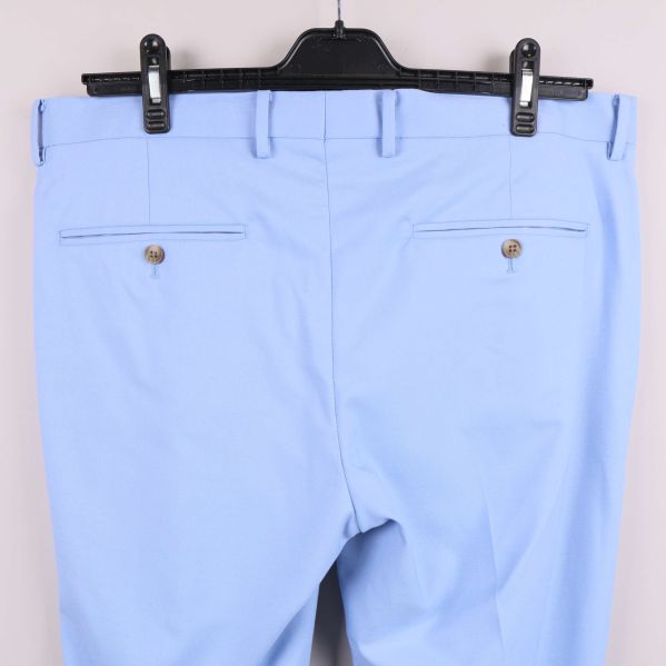 Närbild på bakfickor med knappar på ljusblå byxa