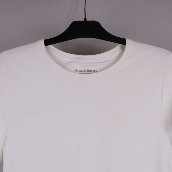 Närbild på halsringning framtill på vit t-shirt