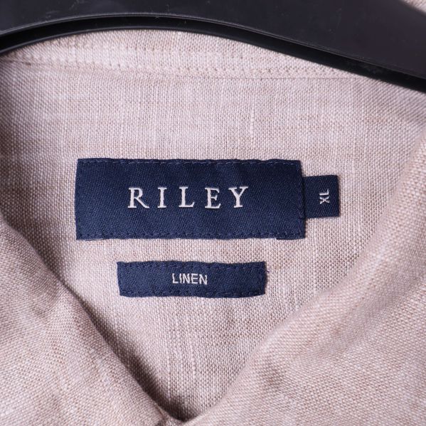 Närbild på Riley-logotyp och storlek XL i skjortans krage