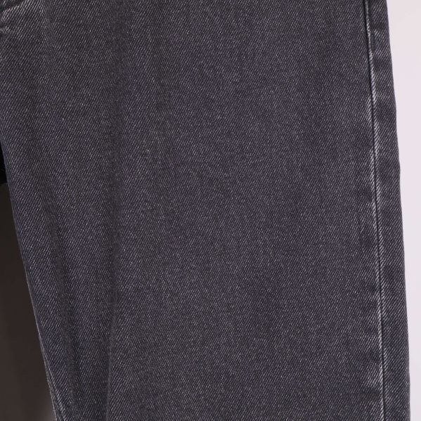 Närbild på benets material och textur på svarta jeans