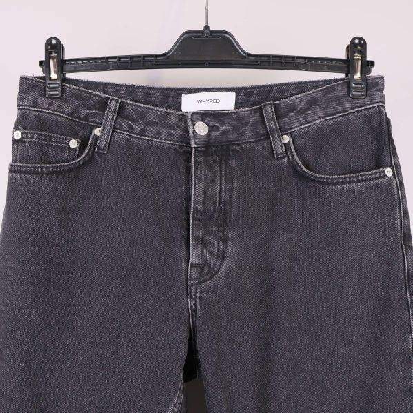 Närbild på midja och fickor av svarta jeans