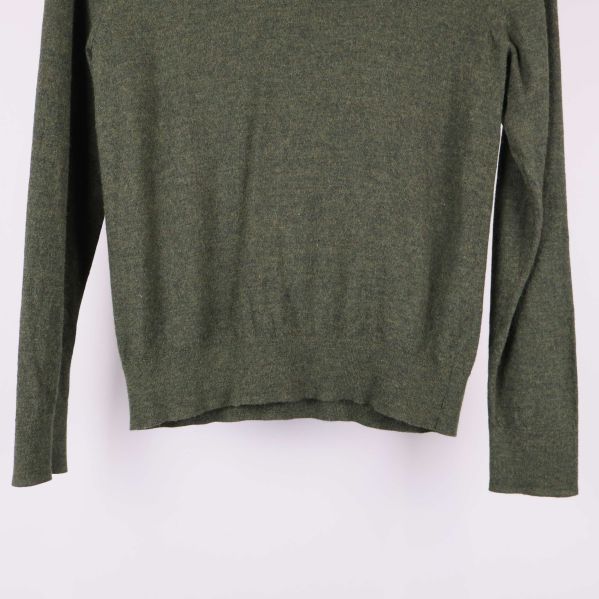 Nedre delen av grön tröja och ärmfåll