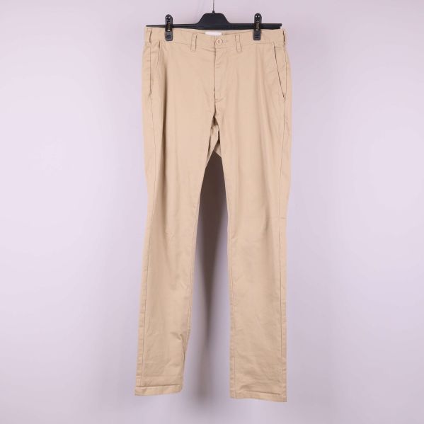 Beiga byxor med raka ben framifrån på galge