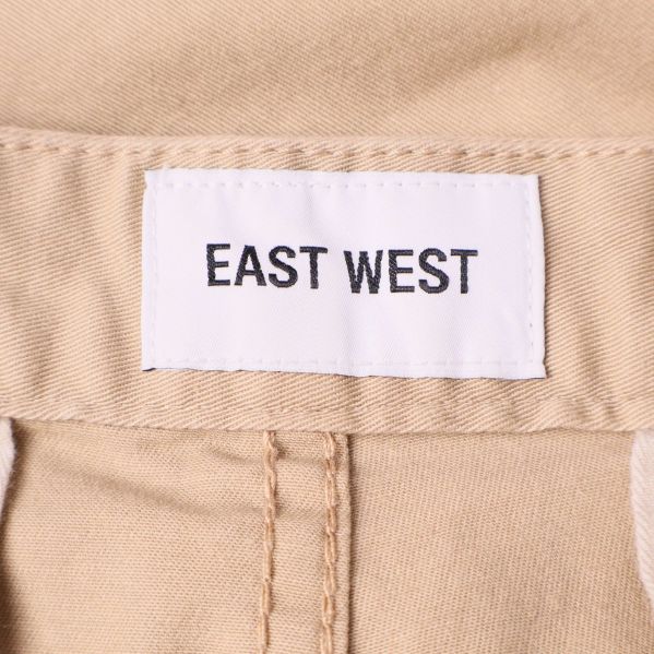 Närbild på etikett med varumärket East West i midjan