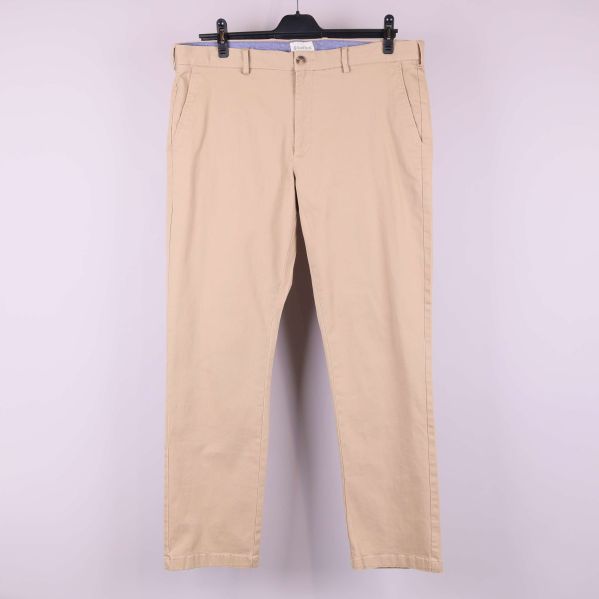 Beiga raka byxor upphängda mot ljus bakgrund