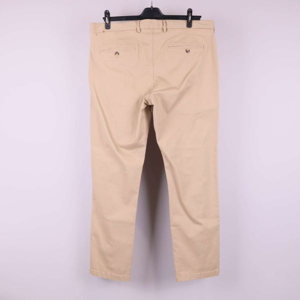 Baksidan av beiga raka byxor med bakfickor