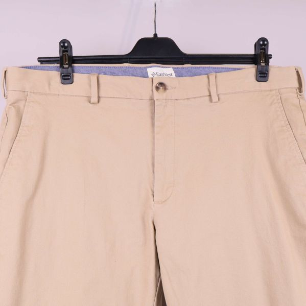 Detaljbild av midja och fickor på beigea byxor