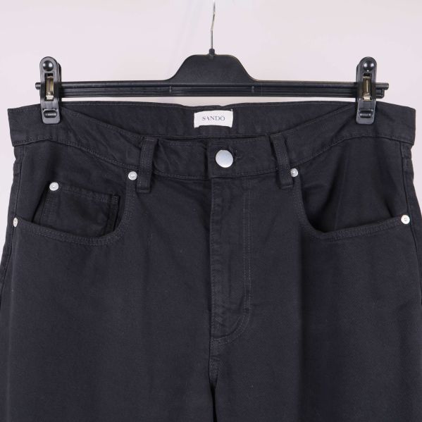 Närbild på framfickor och knapp på svarta byxor