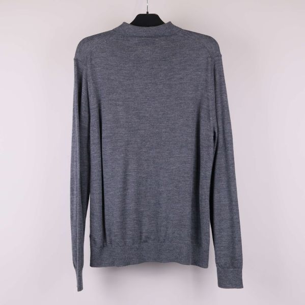 Baksida av grå långärmad polotröja på galge