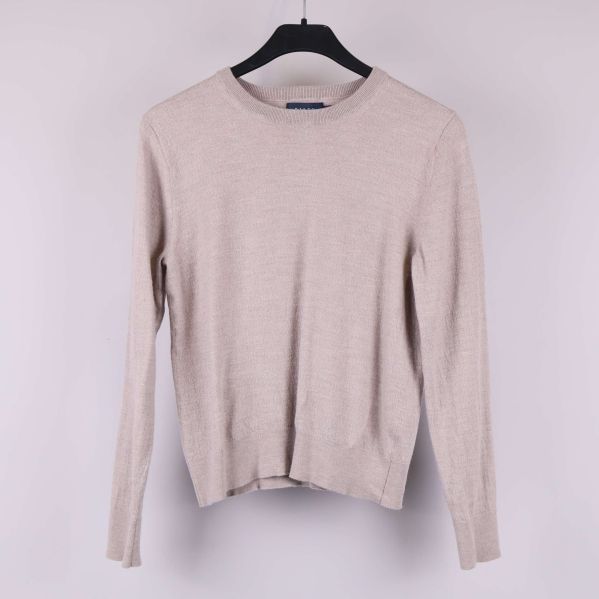 Beige stickad tröja med långa ärmar framifrån på galge