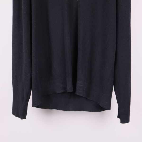 Nedre delen av svart långärmad tröja med ribbad mudd